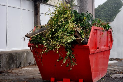 Family loading a skip with household items in Millbank